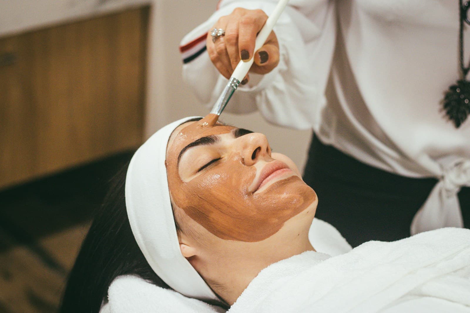 Profesional realizando un tratamiento facial en una clínica luminosa y serena